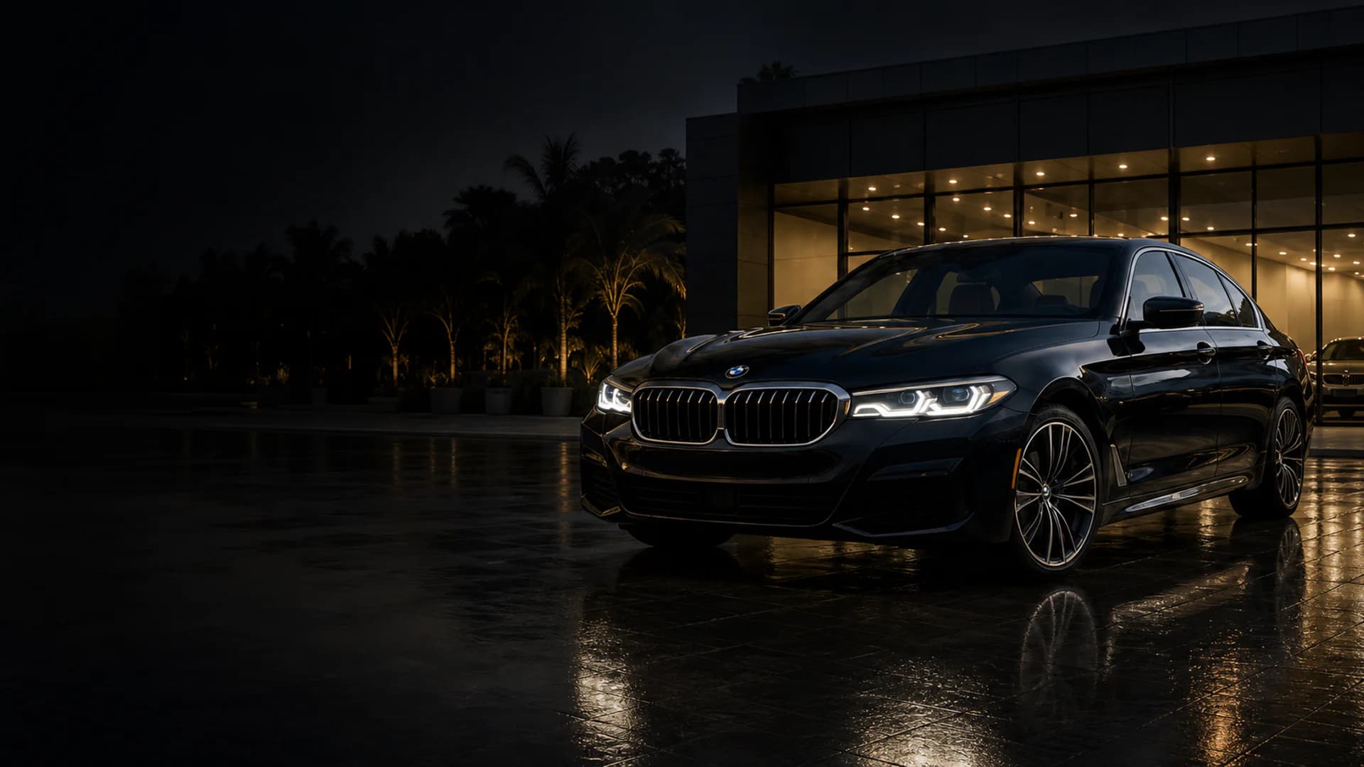 Black BMW 5 Series outside a premium showroom at night
